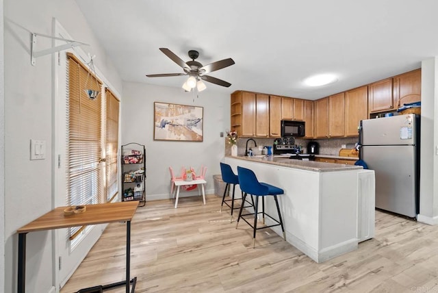 1280 W Main St Unit 42, El Cajon, CA 92020 - kitchen featuring black microwave, freestanding refrigerator, stainless steel electric stove, a ceiling fan, and a peninsula