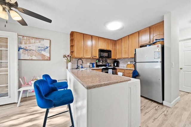1280 W Main St Unit 42, El Cajon, CA 92020 - kitchen with stainless steel appliances, light wood-style flooring, open shelves, light countertops, and a ceiling fan