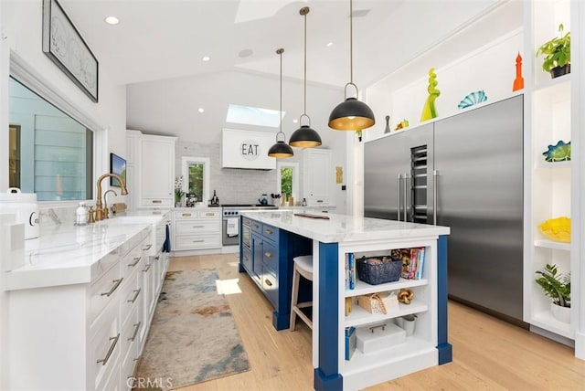 1954 Port Locksleigh Pl, Newport Beach, CA 92660 - kitchen with high quality appliances, open shelves, blue cabinets, white cabinetry, and a kitchen island