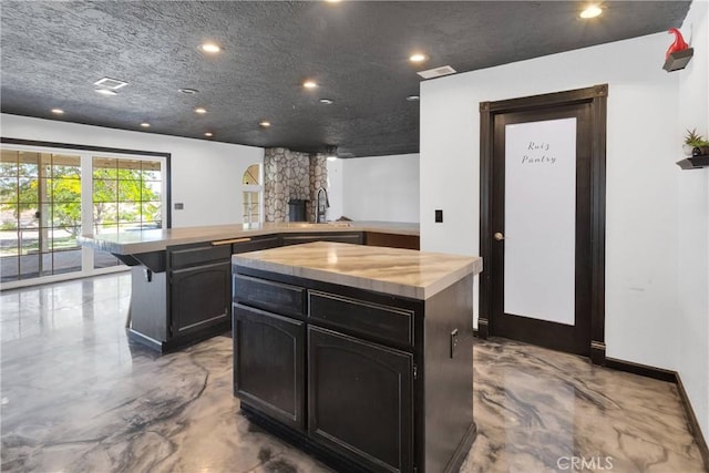 16912 Danbury Ave, Hesperia, CA 92345 - kitchen with wood counters, a center island, recessed lighting, and a stone fireplace
