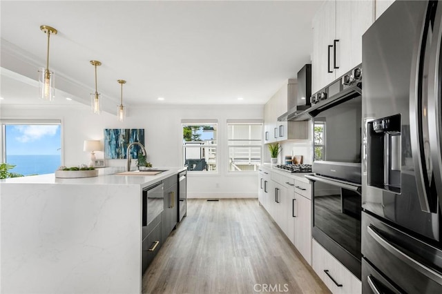 32015 Point Pl, Laguna Beach, CA 92651 - kitchen featuring stainless steel appliances, modern cabinets, light wood-style floors, wall chimney exhaust hood, and decorative light fixtures