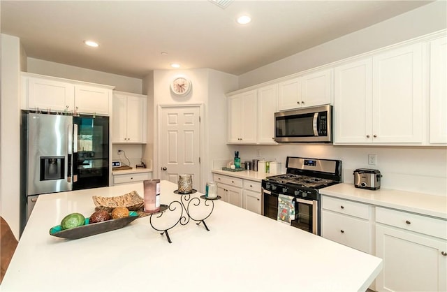 2698 N Arroyo Ave, Fresno, CA 93727 - kitchen with appliances with stainless steel finishes, white cabinets, light countertops, recessed lighting, and a kitchen island