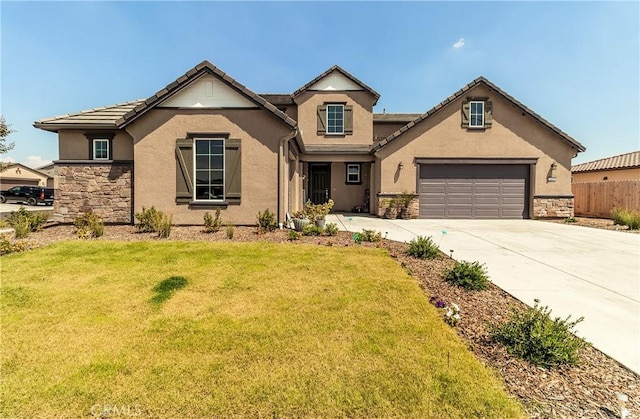 2698 N Arroyo Ave, Fresno, CA 93727 - view of front of house with stone siding, driveway, stucco siding, and an attached garage