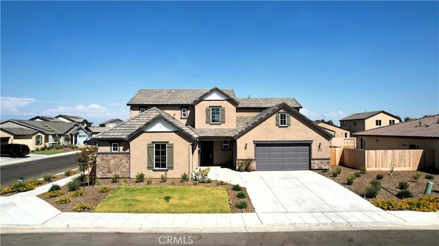 2698 N Arroyo Ave, Fresno, CA 93727 - view of front of property with stucco siding, concrete driveway, stone siding, and a garage