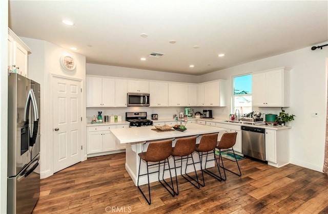 2698 N Arroyo Ave, Fresno, CA 93727 - kitchen with stainless steel appliances, a breakfast bar area, a kitchen island, white cabinets, and recessed lighting