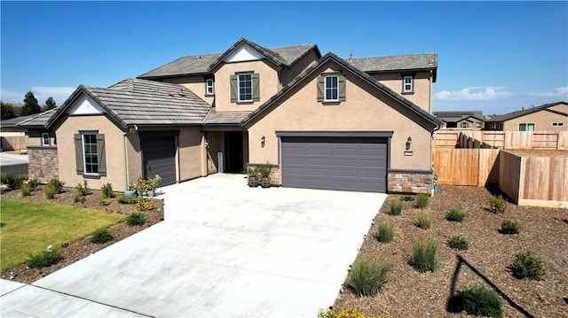 2698 N Arroyo Ave, Fresno, CA 93727 - traditional home with stucco siding, driveway, stone siding, and an attached garage