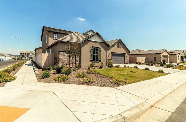 2698 N Arroyo Ave, Fresno, CA 93727 - view of front of house with driveway, an attached garage, stucco siding, a tile roof, and a residential view