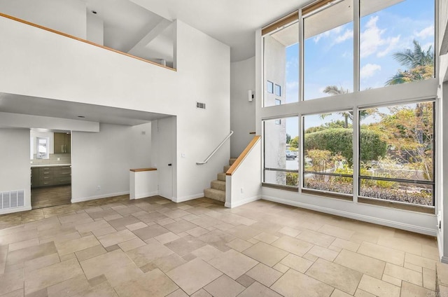3112 N Mountain View Dr, San Diego, CA 92116 - unfurnished living room with a towering ceiling, stone tile floors, and stairs