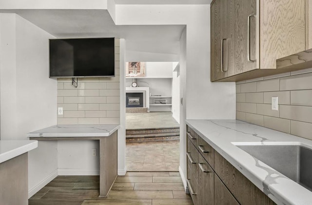 3112 N Mountain View Dr, San Diego, CA 92116 - kitchen featuring a fireplace, dark wood-style floors, backsplash, and light stone countertops