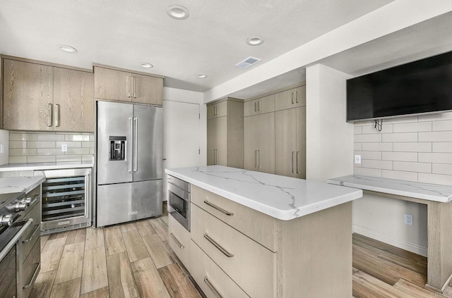 3112 N Mountain View Dr, San Diego, CA 92116 - kitchen featuring appliances with stainless steel finishes, wine cooler, light stone counters, light wood finished floors, and recessed lighting