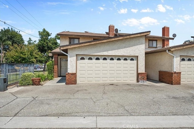 406 Genoa St Unit A, Monrovia, CA 91016 - view of front of property featuring stucco siding, a garage, a chimney, and asphalt driveway