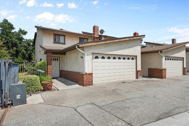 406 Genoa St Unit A, Monrovia, CA 91016 - view of front of home with stucco siding, a garage, brick siding, and driveway