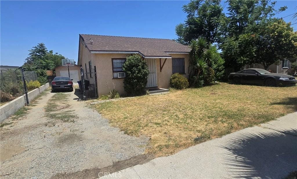 9023 Olive St, Fontana, CA 92335 - view of front facade with driveway, stucco siding, and cooling unit