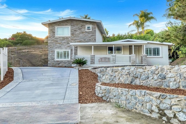 10150 Sierra Madre Rd, Spring Valley, CA 91977 - view of front of property with stone siding, a porch, driveway, and stucco siding