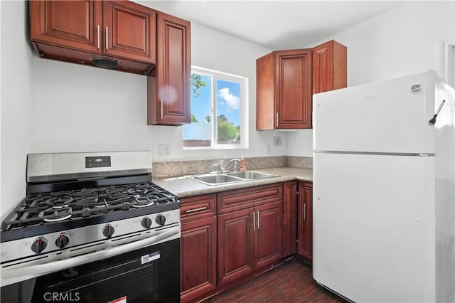 13886 Paxton St, Pacoima, CA 91331 - kitchen with freestanding refrigerator, gas stove, dark wood-style floors, light countertops, and reddish brown cabinets