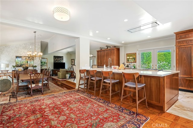 17248 Barneston Ct, Granada Hills, CA 91344 - kitchen with light countertops, brown cabinets, a breakfast bar, open floor plan, and lofted ceiling
