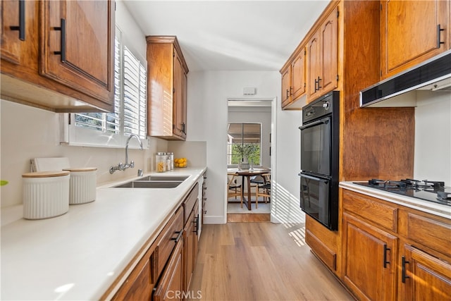 14819 San Feliciano Dr, La Mirada, CA 90638 - kitchen featuring black appliances, light wood finished floors, light countertops, and brown cabinetry
