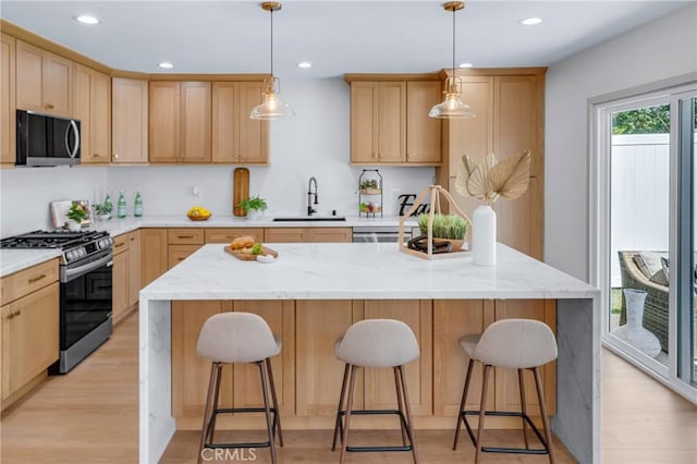 5621 E Carita St, Long Beach, CA 90808 - kitchen featuring gas stove, light brown cabinets, a breakfast bar, light wood-style floors, and recessed lighting