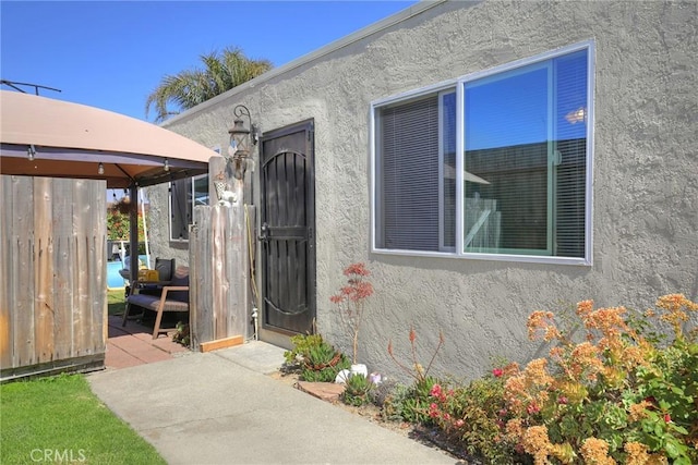 560 S 12th St, Grover Beach, CA 93433 - view of exterior entry with stucco siding and a patio
