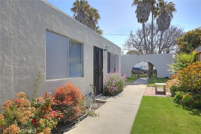 560 S 12th St, Grover Beach, CA 93433 - property entrance with stucco siding and a yard