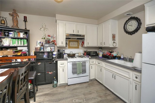 560 S 12th St, Grover Beach, CA 93433 - kitchen with white appliances, under cabinet range hood, white cabinets, and light wood finished floors