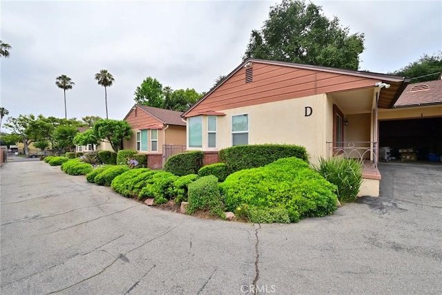 517 E Washington Blvd, Pasadena, CA 91104 - view of home's exterior featuring a garage, stucco siding, and asphalt driveway