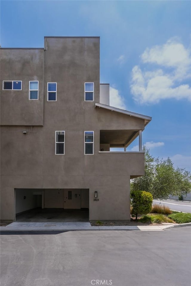 2823 Lily Ln, El Monte, CA 91733 - view of home's exterior with stucco siding, a garage, and asphalt driveway