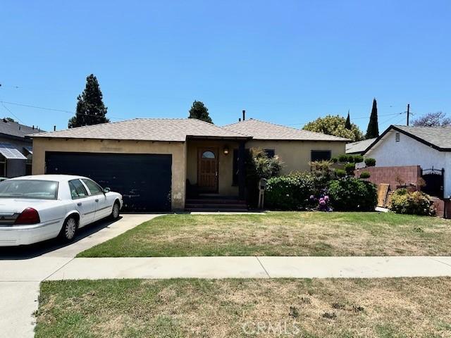 2616 E 220th Pl, Long Beach, CA 90810 - single story home featuring a garage, concrete driveway, stucco siding, and a front lawn