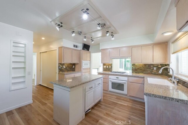2158 N Ave, Chico, CA 95926 - kitchen with white appliances, light brown cabinetry, light wood finished floors, a center island, and tasteful backsplash