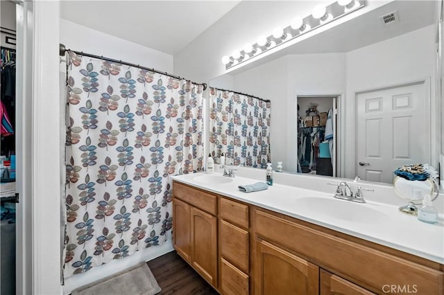 15655 Vista Way Unit 100, Lake Elsinore, CA 92532 - bathroom featuring a walk in closet, double vanity, wood finished floors, and a shower with shower curtain