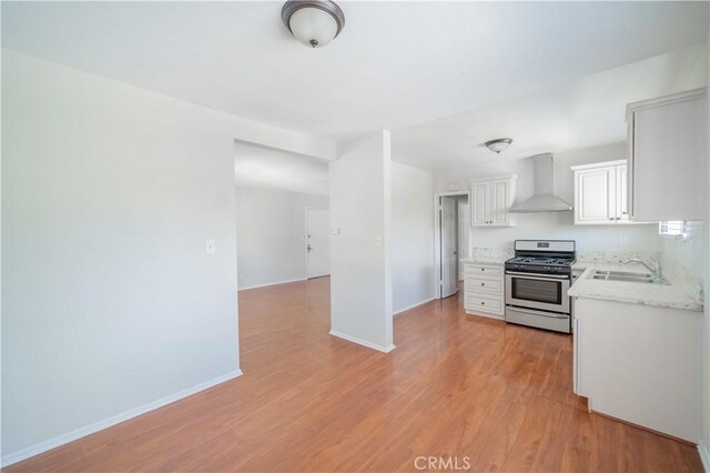 610 N Oakland Ave, Pasadena, CA 91101 - kitchen with gas range, wall chimney exhaust hood, light wood-style flooring, white cabinets, and light stone countertops