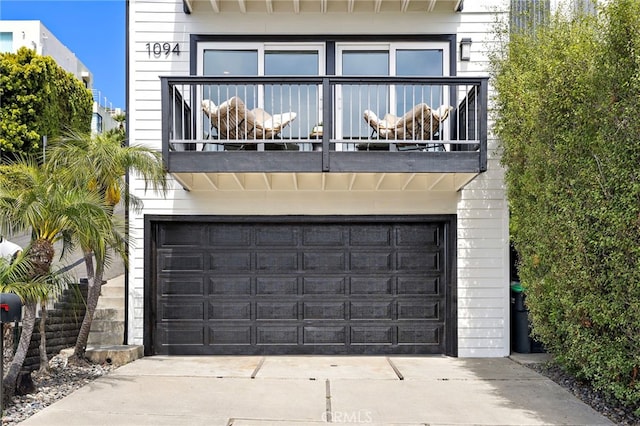 1094 Katella St, Laguna Beach, CA 92651 - rear view of house featuring a balcony, a garage, and concrete driveway
