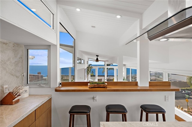 1094 Katella St, Laguna Beach, CA 92651 - kitchen with brown cabinetry, a kitchen breakfast bar, plenty of natural light, modern cabinets, and recessed lighting