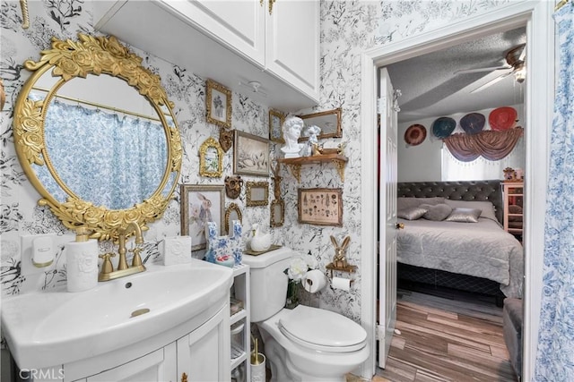 178 E 49th St, Los Angeles, CA 90011 - ensuite bathroom featuring wallpapered walls, vanity, wood finished floors, and ceiling fan
