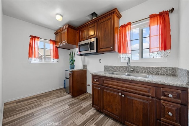 178 E 49th St, Los Angeles, CA 90011 - kitchen featuring stainless steel microwave, light wood-type flooring, and light countertops