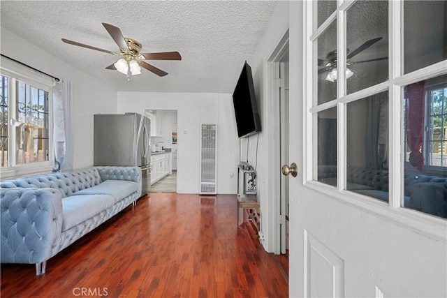 178 E 49th St, Los Angeles, CA 90011 - living room with a heating unit, a ceiling fan, dark wood-style flooring, and a textured ceiling