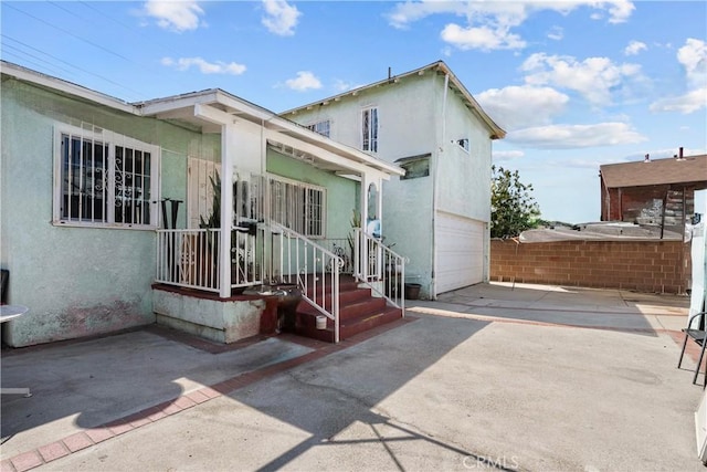 178 E 49th St, Los Angeles, CA 90011 - rear view of property with stucco siding, driveway, and a garage