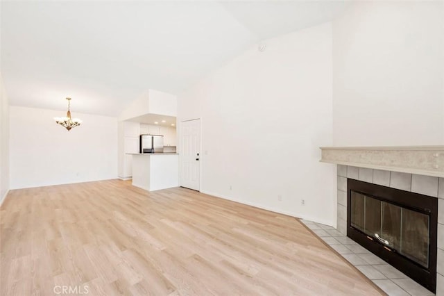 42140 Lyndie Ln Unit 12, Temecula, CA 92591 - unfurnished living room with lofted ceiling, a chandelier, a fireplace, and light wood-style floors