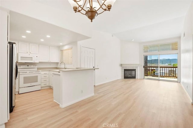42140 Lyndie Ln Unit 12, Temecula, CA 92591 - kitchen with white appliances, light wood-style flooring, a chandelier, open floor plan, and a peninsula