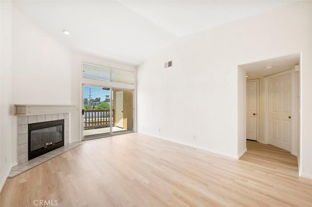 42140 Lyndie Ln Unit 12, Temecula, CA 92591 - unfurnished living room featuring light wood-style flooring, a tile fireplace, and lofted ceiling