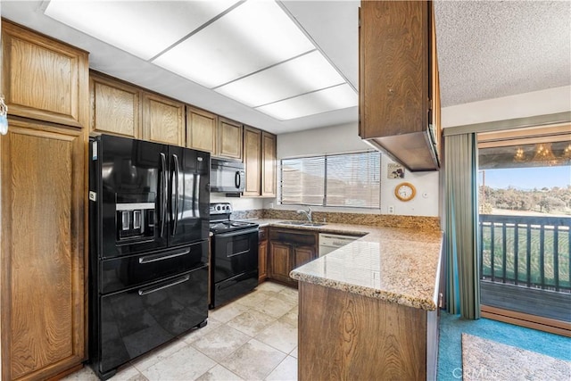 6991 Caminito Perico, San Diego, CA 92119 - kitchen with black appliances, light stone counters, light tile patterned floors, and brown cabinetry