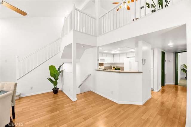 1026 N Turner Ave Unit 223, Ontario, CA 91764 - unfurnished living room with a ceiling fan, light wood finished floors, stairway, recessed lighting, and a high ceiling