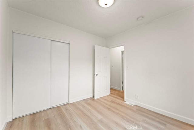 5840 S Olive St, Los Angeles, CA 90003 - unfurnished bedroom featuring light wood-style floors and a closet