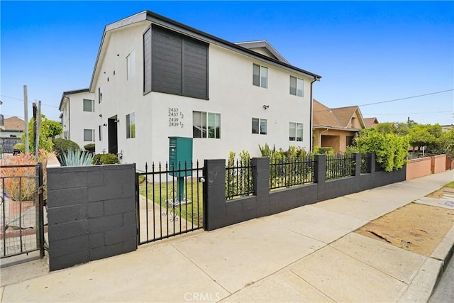 2437 Malabar St, Los Angeles, CA 90033 - view of side of home with a fenced front yard, stucco siding, and a gate