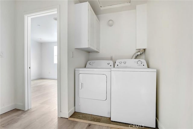 2437 Malabar St, Los Angeles, CA 90033 - laundry area featuring separate washer and dryer, light wood-style floors, and cabinet space