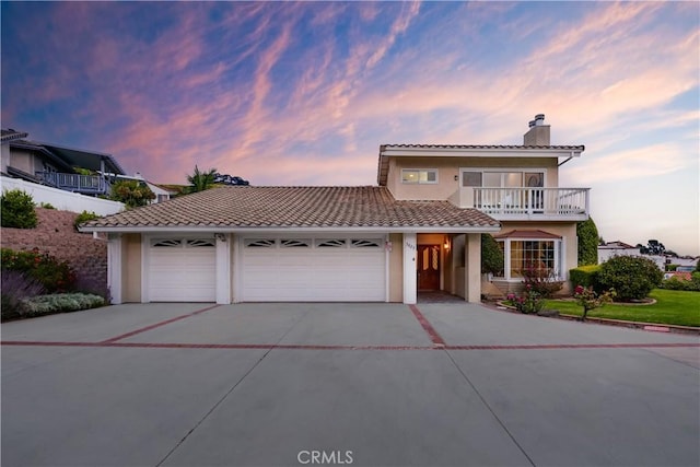 3823 Via Manzana, San Clemente, CA 92673 - view of front of house featuring a chimney, driveway, stucco siding, a balcony, and an attached garage
