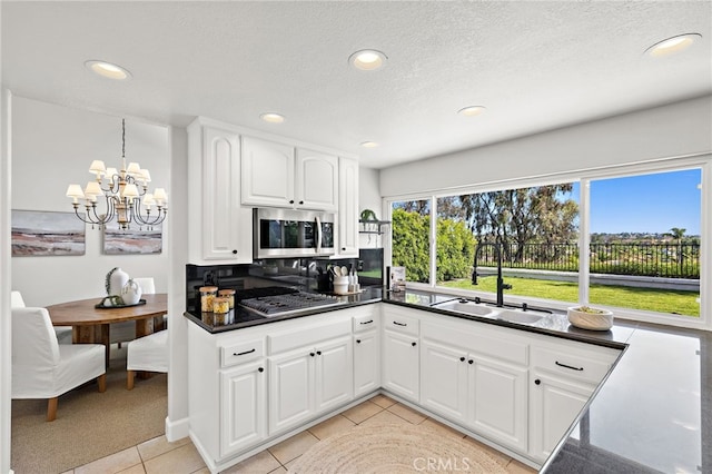 10 Novilla, Laguna Niguel, CA 92677 - kitchen featuring appliances with stainless steel finishes, dark countertops, recessed lighting, a chandelier, and white cabinetry