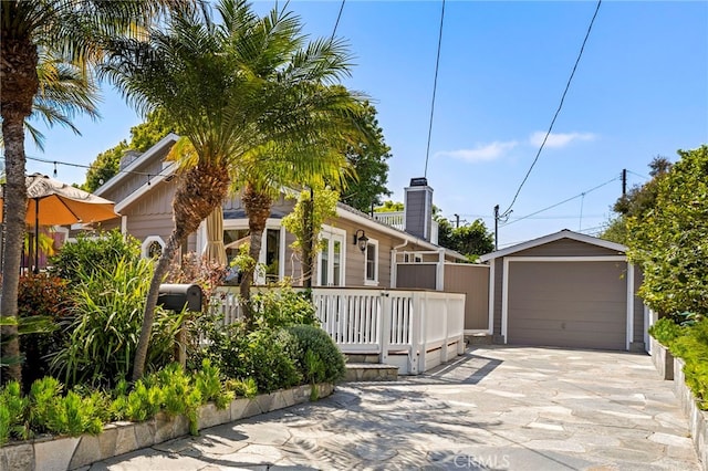 430 Anita St, Laguna Beach, CA 92651 - view of front of property with an outdoor structure, a garage, concrete driveway, and a chimney