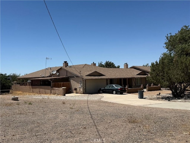 7236 Coyote Trl, Oak Hills, CA 92344 - view of front facade with a garage, driveway, and a chimney
