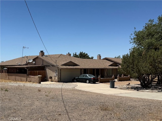 7236 Coyote Trl, Oak Hills, CA 92344 - ranch-style home featuring an attached garage, concrete driveway, and a chimney